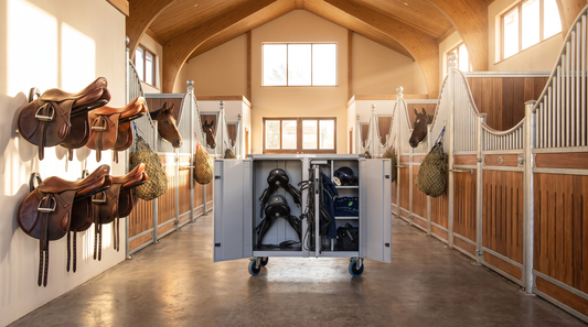 Paddock Blade Deluxe Large Aluminum Tack Locker in a multi-horse barn aisle with saddles nearby